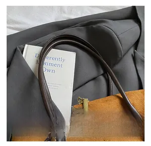 Détails du sac Boston en daim marron avec anses cylindriques et fermeture éclair dorée