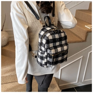 Dettaglio mini zaino in tweed a scacchi bianco e nero con chiusura lampo in metallo dorato