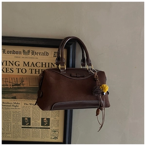 Détail d'un sac à main vintage marron foncé avec des franges et des surpiqûres