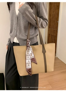 Detail of minimalist beige tote bag with brown handles and cartoon bear silk scarf
