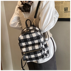 Dettaglio mini zaino in tweed a quadri bianchi e neri con cerniere in metallo dorato