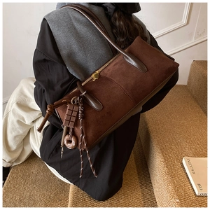 Vue détaillée du sac à bandoulière en daim marron avec breloques chocolat créatives