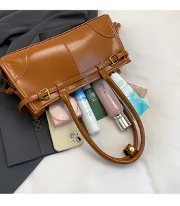 Detail view of large brown shoulder bag interior showing spacious storage and metal buckles