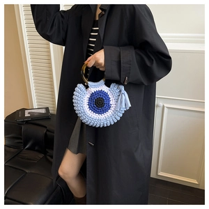 Détail du sac en crochet avec motif œil et poignées rondes en écaille de tortue