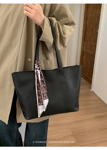Minimalist black tote bag with heart pattern scarf accent on shoulder strap