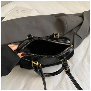 Top view of black leather handbag showing spacious interior and golden metal zipper detail