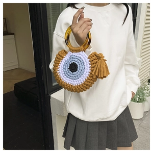 Détail de sac à main au crochet Evil Eye avec poignée en résine et pompon en coton