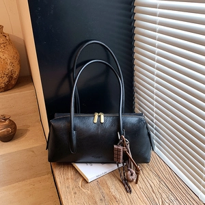 Sac Boston vintage en cuir noir avec fines bretelles et breloques de sac élégantes