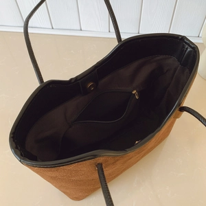 Interior view of brown suede tote bag showing magnetic buckle and zipper pockets