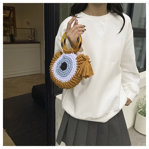Détail du sac en crochet avec motif œil et poignées en résine à texture ambre