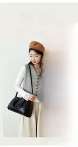 Detailed views of a black pebbled leather boston bag with metal zippers and reinforced handles