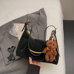 Black matte crescent shoulder bag with gold hardware and plush bear charm for women