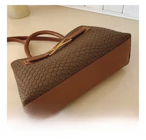 Detailed macro view of brown woven leather texture and premium gold V-shaped buckle