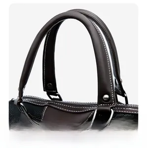 Detail of dark lychee grain leather handbag with brown handles and white contrast stitching