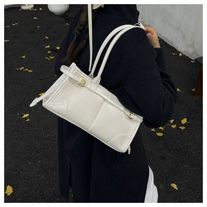 Macro detail of white glossy leather texture and gold metal buckles on a vintage shoulder bag