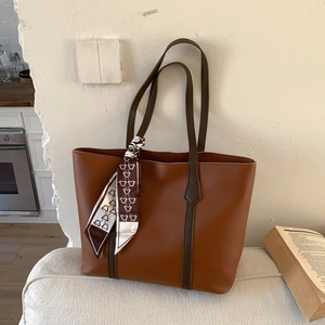 Brown leather tote bag with contrast handles and bear pattern silk scarf accessory