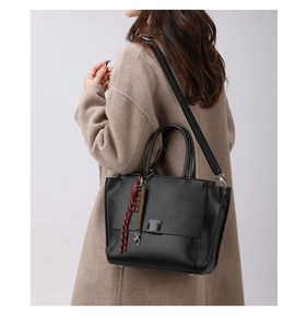 Detail van zwarte lychee-leren shopper met stijlvolle touwhanger aan de lange schouderband