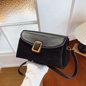 Minimalist black leather crossbody bag with gold buckle and textured contrast finish