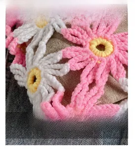 Macro detail of handmade crochet flower bag with cotton lining and pink knit petals