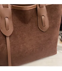 Close-up detail of dark brown matte suede tote bag with reinforced leather handles
