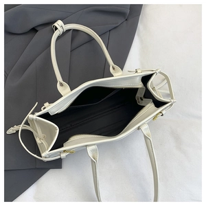 Overhead view of a spacious white tote bag interior with black lining and secure zipper pocket