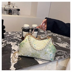 Detail of vintage floral jacquard evening bag with pearl handle and metal clasp