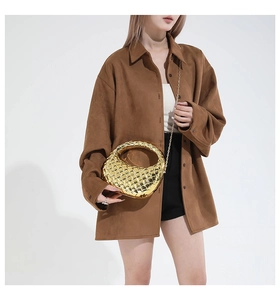 Detailed view of golden woven texture handbag with metallic finish and chain strap