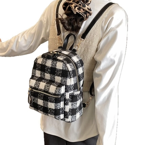 Zaino invernale in tweed a scacchi bianco e nero con texture morbida e dettagli oro