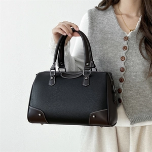 Minimalist black lychee leather Boston pillow bag with brown base and silver studs