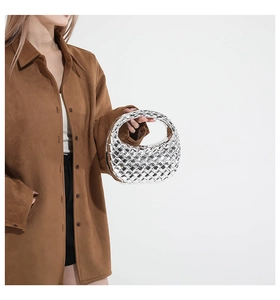 Fashionable silver woven hobo bag shown on model with minimalist geometric texture