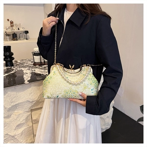 Détail du sac à main brodé floral vintage avec poignée en perles et cadre doré
