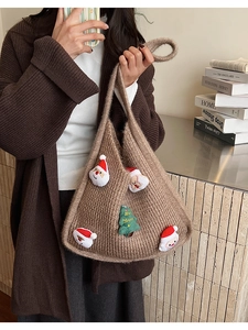 Detail of a brown knit tote bag with Santa Claus patches and Christmas tree embroidery