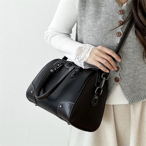 Classic black leather boston bag with white contrast stitching and dual top handles