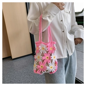 Detail of handmade crochet floral tote bag with pink and white daisy patterns and shoulder strap