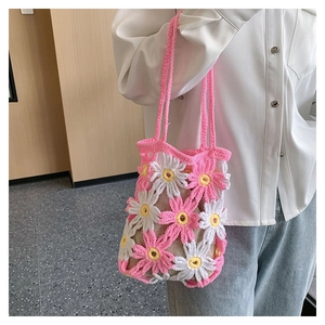 Detail of handmade crochet handbag with pink and white daisy flower patterns
