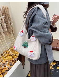 Detail of knit tote bag with 3D Santa and Christmas tree plush patches in autumn setting