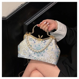 Detail of floral brocade evening bag with pearl handle and rhinestone metal frame