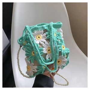 Detailed view of handmade crochet daisy pattern bag with pearl strap and knit handle