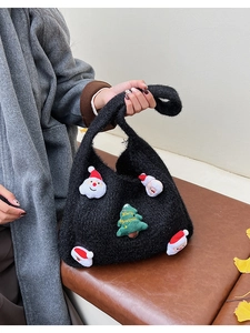 Detail of black woven tote bag with Christmas 3D patches and ginkgo leaves background