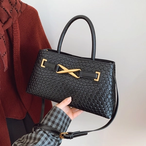 Fashionable black woven handbag with gold X-buckle and adjustable shoulder strap