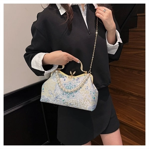 Detail of vintage floral embroidery bag with white pearl handle and gold chain strap