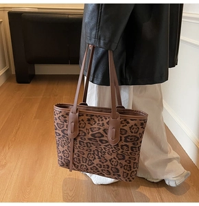 Detailed macro shot of the leopard print pattern and dual straps on the tote bag