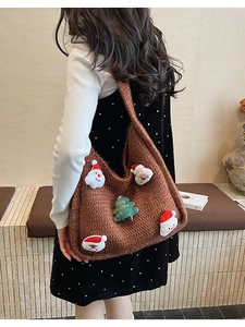 Close-up of brown knit tote bag featuring plush Santa and Christmas tree patches