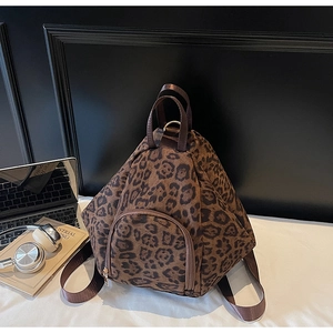 Vue de haut d'un sac à dos imprimé léopard au design triangulaire à côté d'un ordinateur