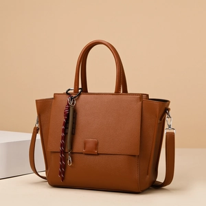 Brown litchi textured tote bag with detachable strap and red white braided charm
