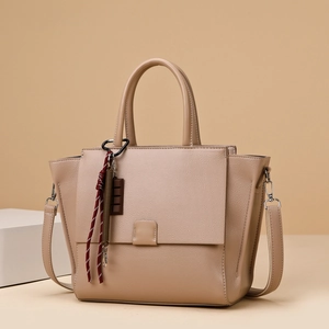 Minimalist beige textured leather tote bag with top handles and a crossbody strap