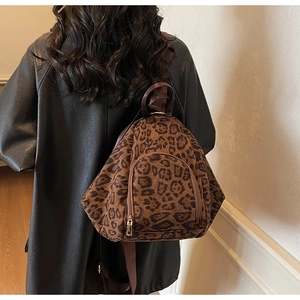 Vue arrière d'un mannequin portant un sac à dos léopard tendance avec fermetures éclair