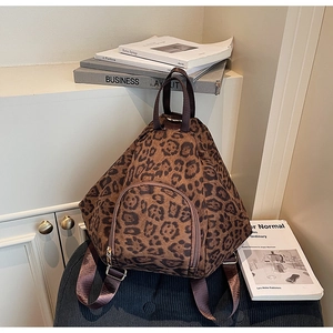 Vue détaillée du sac à dos léopard avec fermetures argentées sur une étagère blanche