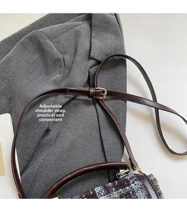 Détail de la bandoulière réglable en cuir marron avec boucle dorée sur sac en tweed