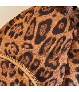 Gros plan sur la texture pelucheuse léopard avec détails de fermeture éclair et sangle